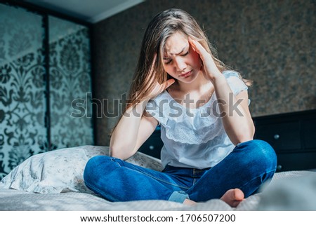 Stress woman having a migraine / headache holding her head in pain and stress. Royalty-Free Stock Photo #1706507200