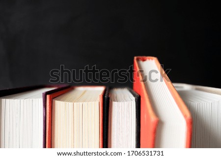 Stack of books with selective focus on black background with copy space. Conceppt choice
