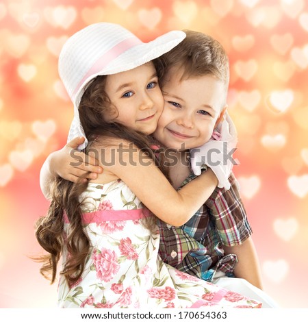 Portrait of funny little boy and a cute girl hugging