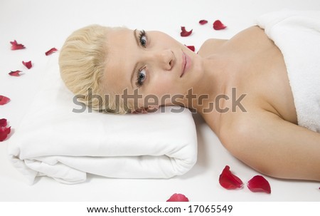 pretty laying woman with rose petals on white background