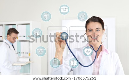 smiling woman doctor with stethoscope pointing medical symbols icons on medical clinic background