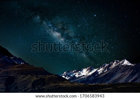 Milky Way with stars shining brightly beautiful at night over the snow- capped mountains at south island new zealand Royalty-Free Stock Photo #1706583943