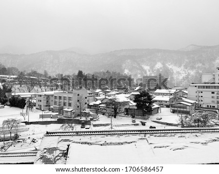 snow covered house in town.winter view of aizu-wakamatsu,tohoku,japan.black and white city.