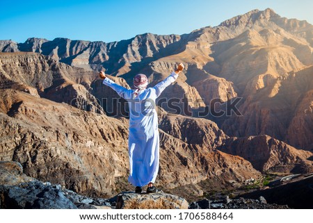 Arab man enjoying the view at the Jebel Jais desert sandstone mountain in Ras al Khaimah UAE Royalty-Free Stock Photo #1706588464