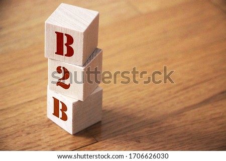 B2B business to business concept. Stack of wooden cubes on wooden floor.