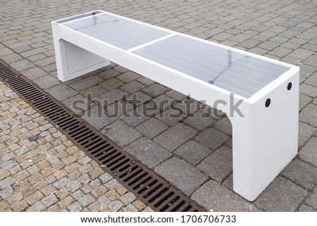 Bench with solar battery to power wifi and charge mobile devices. Royalty-Free Stock Photo #1706706733
