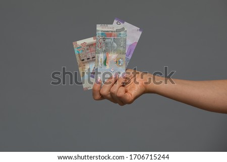 Kuwaiti dinar banknote in hand of young woman. Kuwaiti dinar is the national currency of Kuwait