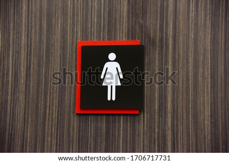 
White female symbol on a black background, overlapping red in the middle, wooden background
