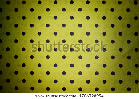 Yellow background with a black dot with a paper texture