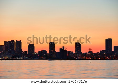Toronto sunset silhouette at dusk over lake with urban architecture.