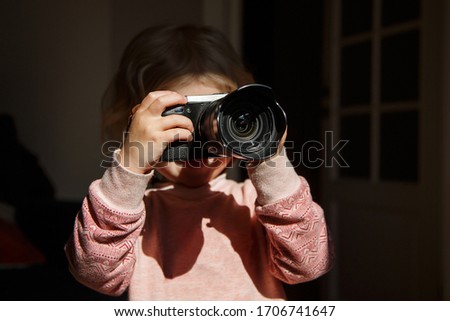 a child learns to take pictures with a camera
