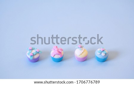 Toy little cupcakes for Easter. On pastel-colored background in pastel colors there are 4 cakes.
