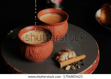 Masala Tea is Popularly known in India as Masala Chai or Herbal tea is under process of Pouring in Earthen cups known as Kulhad. (Masala Chai/Kulhad chai) Royalty-Free Stock Photo #1706805625
