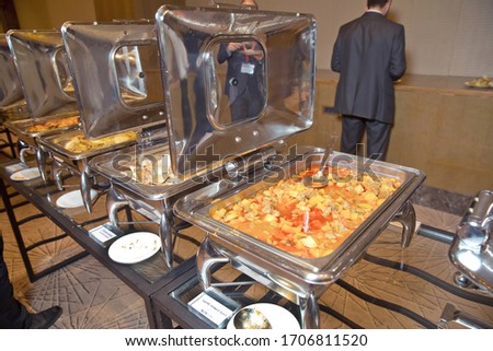 warm chafing dishes for heating food in hotel buffet banquet . Table with utensils and mirror boilers for meal . a closeup photo of dishware for a restaurant . Lamb Lamb stewed . Chicken breast .
