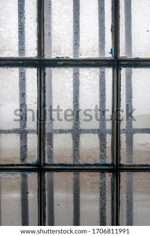 Detail of window with railings, with sea in a rainy day in the background. Concept: closed place interior