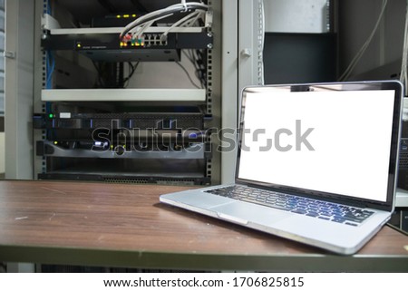 Laptop with blank screen on table. Interior or office background.