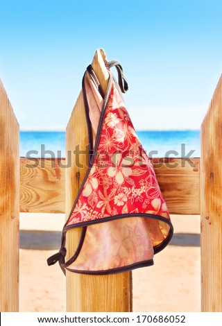 Women's swimsuit hanging on a rope on the fence near beach on the fence