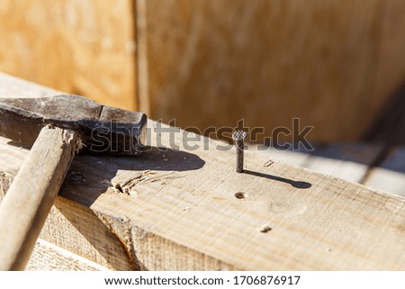 Carpenters uses a hammer to driving nail, Craftsmen and builder equipment. A man hammers an iron nail into a wooden beam