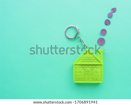Concept of a mortgage agreement with a keychain in the form of a house, real estate insurance with a copy of the space