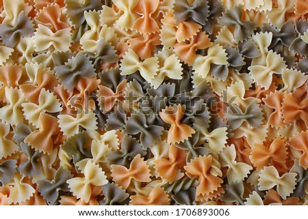 Colorful Italian pasta background. Various colors of bow tie farfalle pasta. Top view.Creative food background.