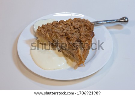 A slice of home baked apple crisp cake with a serving of clotted cream 