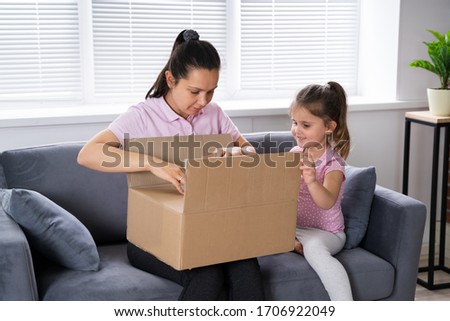 Happy Woman And Kid Opening Received Package From Online Shop