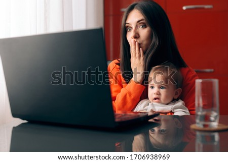 Happy Mother and Baby Watching Cartoon on the Laptop. Mom and young infant spending educational quality time online
