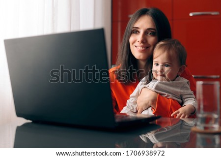 Happy Mother and Baby Watching Cartoon on the Laptop. Mom and young infant spending educational quality time online
