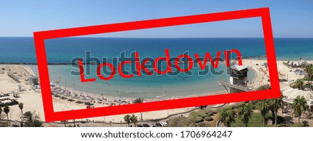 Panoramic photo of the sea beach with a red diagonal stamp "Lockdown" because of the coronovirus pandemic.