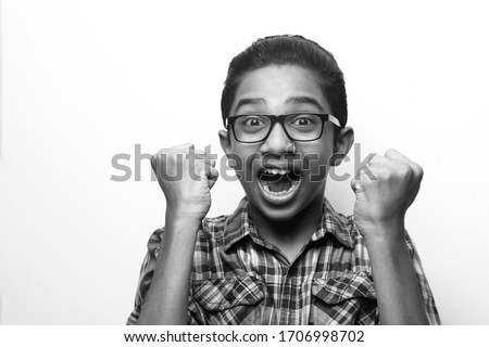 Black and white portrait of a cheering young boy