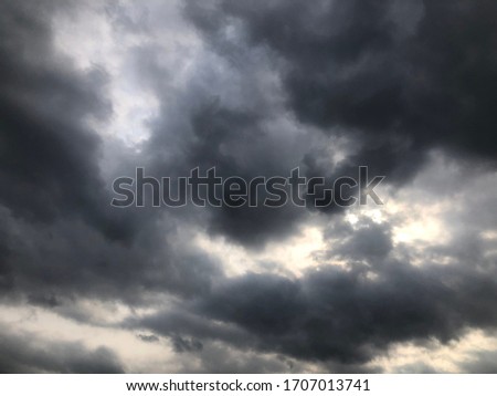 Atmosphere of dark overcast before change to rainy. Dark cloudy full over sky cover the sun as smoke texture background. Sunlight through the cloudy sky.
