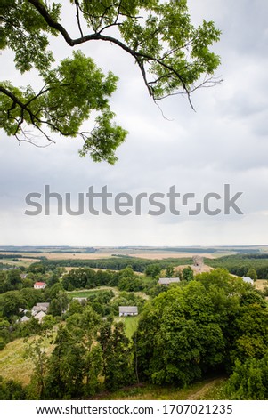 Scenic view on Pidkamin inselberg on adjacent hill and nearby village in Brody region of Galychyna, Ukraine