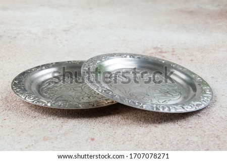 Old metal coasters, small dish on concrete background. Copy space for text.