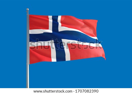 Norway national flag waving in the wind on a deep blue sky. High quality fabric. International relations concept. Royalty-Free Stock Photo #1707082390