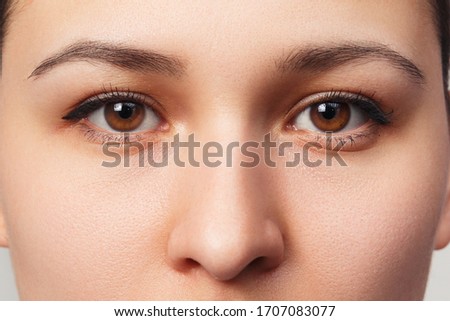 Eyes woman close-up face. Macro beauty portrait of a woman with brown eyes. Royalty-Free Stock Photo #1707083077