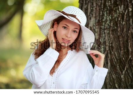 Young and pretty girl with a white hat in summertime