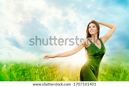 Outdoor Portrait of Beautiful Young Woman. Attractive Girl in Green Field Blue Sunny Sky in Rays of Sun Light
