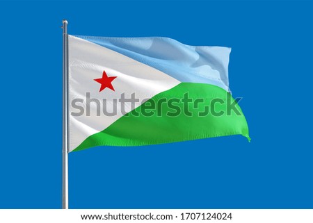 Djibouti national flag waving in the wind on a deep blue sky. High quality fabric. International relations concept.