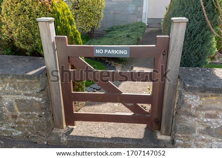a close up view of a front gate that has a no parkign sign on the front 