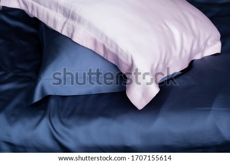 Pillows in blue and pink silk. Silk pillowcases. Satin bedding. Royalty-Free Stock Photo #1707155614