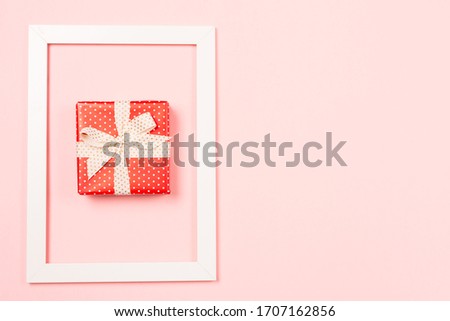 Boxing day template. Red Gift box in frame on pastel pink background. St Valentine's Day Mothers's Day Wedding Birthday concept. Copy space. Space for text. Free space. Flat lay. Top view. 