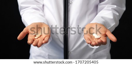 Cropped view of female Doctor holding in hands Pills to choose. Difficult Choice between drugs. Placebo drugs concept. Healthcare concept. Royalty-Free Stock Photo #1707205405