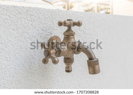 Garden faucet mounted on the wall of the house