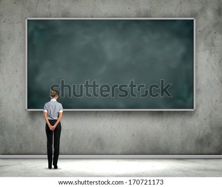 Rear view of businesswoman looking at chalkboard