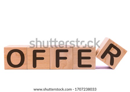 Word OFFER is made of wooden building blocks lying on the table and on a light background. Concept.