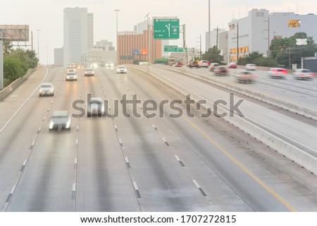 Aerial view rush hour traffic in downtown Houston, Texas, America. Long exposure slow motion many cars commute on interstate highway at late afternoon with light trail, high-occupancy vehicle lane