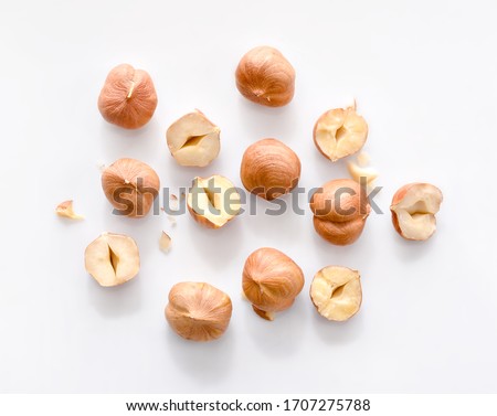 Full and half of hazelnuts on white background top view. Isolated Royalty-Free Stock Photo #1707275788