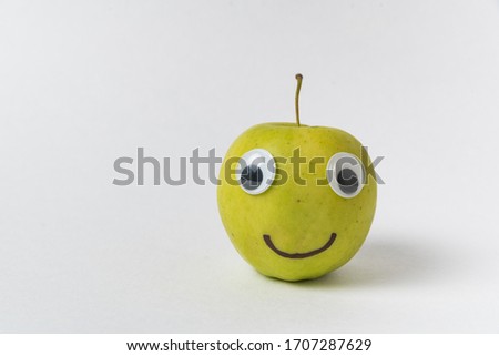 Apple smiley on white background. Apple with Googly eyes and drawn smile