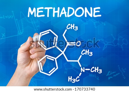 Hand with pen drawing the chemical formula of methadone