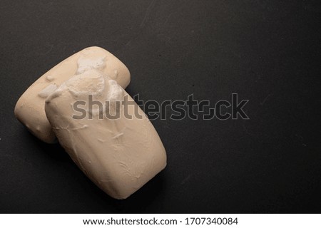 Two pieces of toilet soap on a black background. Close up. Washing hands with soap is a prevention of COVID-19 infection.